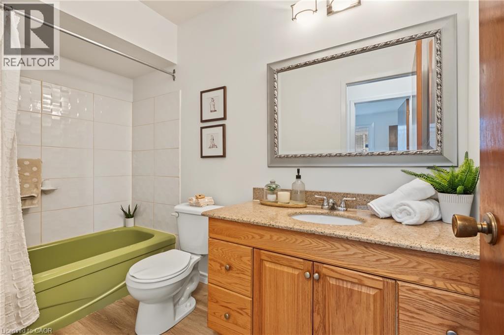 Bedroom level FULL 4PC Bathroom; updated oversized vanity, NEW vinyl flooring, NEW light fixture. - 589 Mohawk Road W, Hamilton, ON