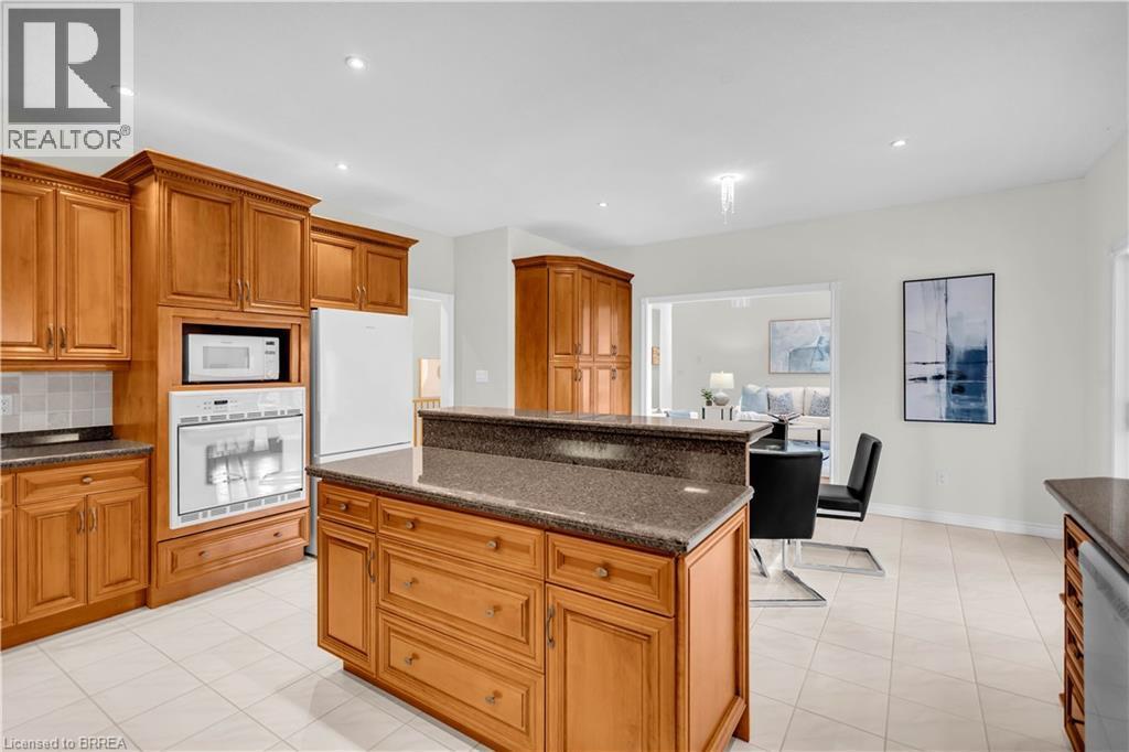 Kitchen featuring a central island with a multi-level countertop, light wood cabinetry, recessed lighting, and tile flooring - 302 German School Road, Paris, ON