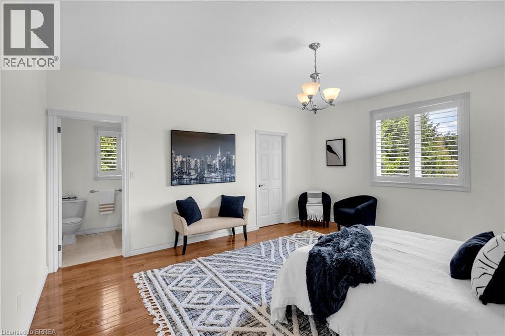 Spacious bedroom with wood-finish flooring and white walls - 302 German School Road, Paris, ON