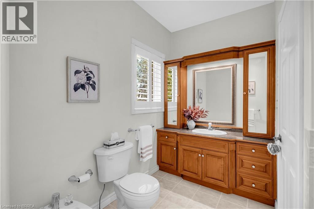 Wood-finish vanity with integrated sink, stone-finish countertop, and framed mirror - 302 German School Road, Paris, ON
