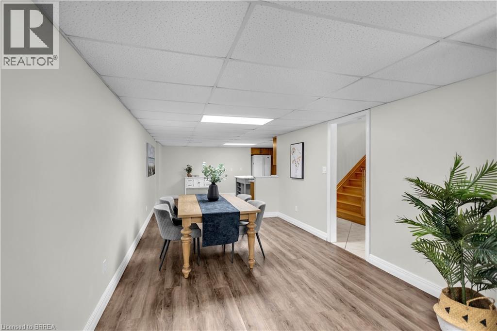 Finished lower level offering wood-finish flooring, light grey painted walls, white trim, and a drop ceiling with recessed lighting - 302 German School Road, Paris, ON