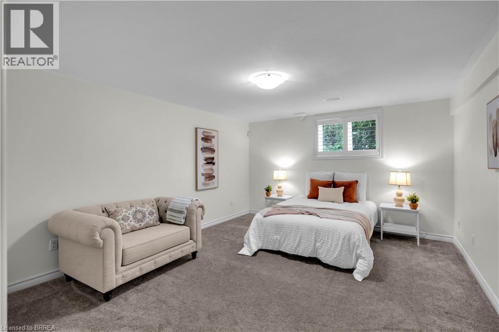 Carpeted room with a ceiling-mounted light fixture, white walls, and a window with white louvered shutters - 302 German School Road, Paris, ON