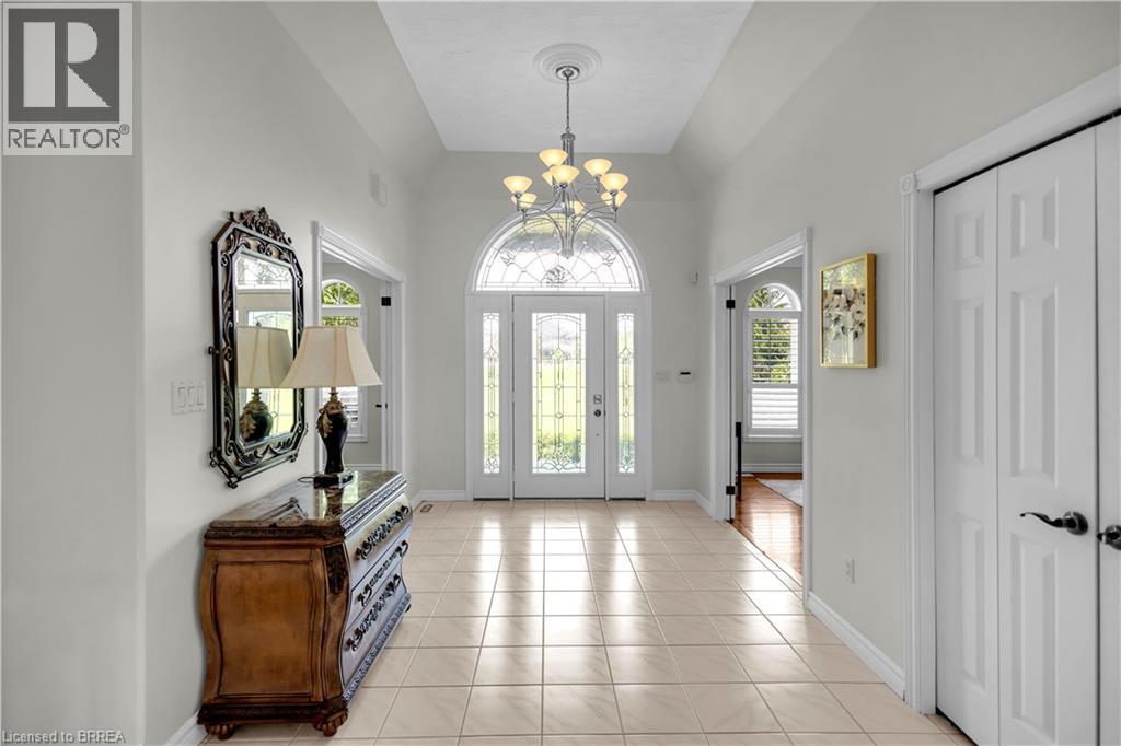 Grand entry foyer featuring tile flooring, vaulted ceiling, and a prominent chandelier - 302 German School Road, Paris, ON