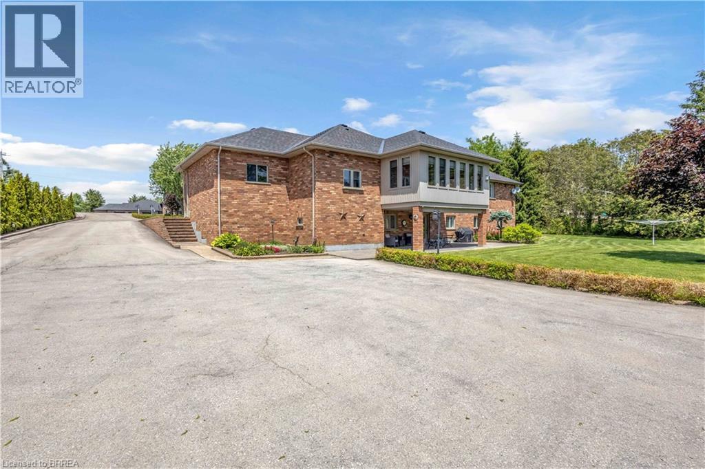 Brick exterior residence featuring a substantial paved driveway - 302 German School Road, Paris, ON