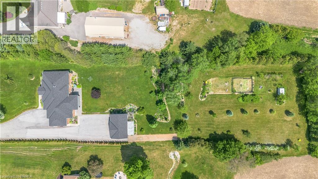 Expansive property featuring a multi-gabled main residence, a detached auxiliary building, and a large cultivated garden area - 302 German School Road, Paris, ON
