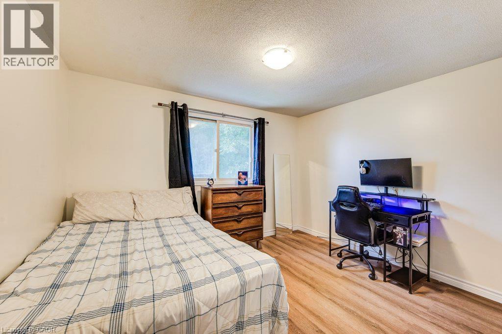 Neutral wall paint, wood-finish flooring, a window with dark curtains, and a ceiling-mounted light fixture - 143 Sunrise Place, Kitchener, ON