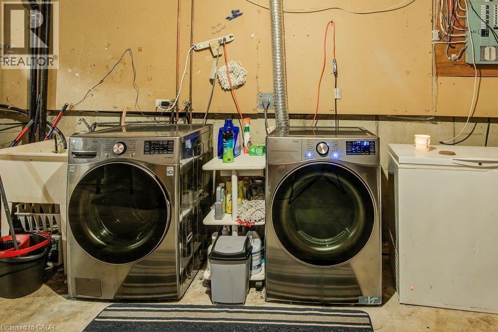 Dedicated laundry area featuring a utility sink and concrete flooring - 143 Sunrise Place, Kitchener, ON