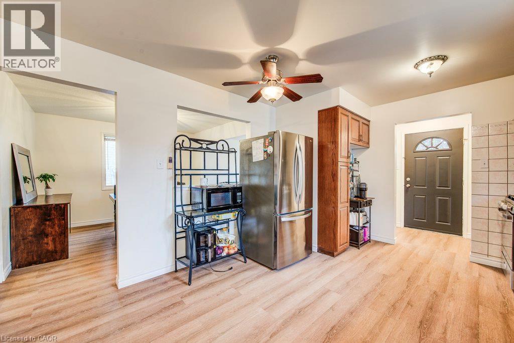 Wood-finish flooring throughout, complemented by a ceiling fan with integrated lighting - 143 Sunrise Place, Kitchener, ON