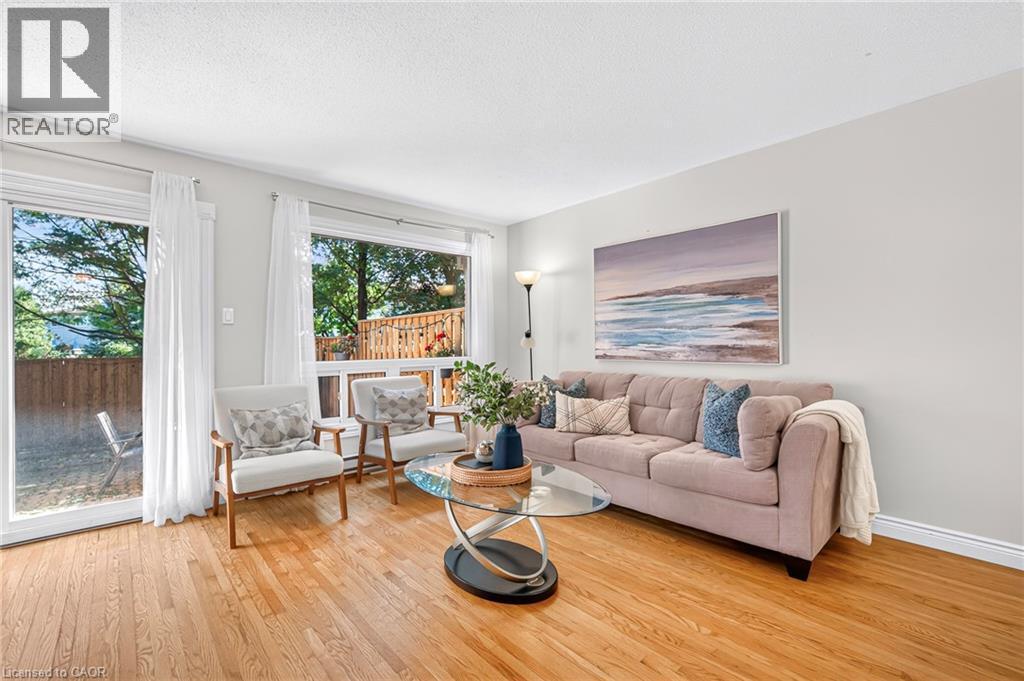 Hardwood flooring, painted walls, large window with natural light, glass sliding door, and white trim throughout - 1517 Elm Road Unit# 9, Oakville, ON