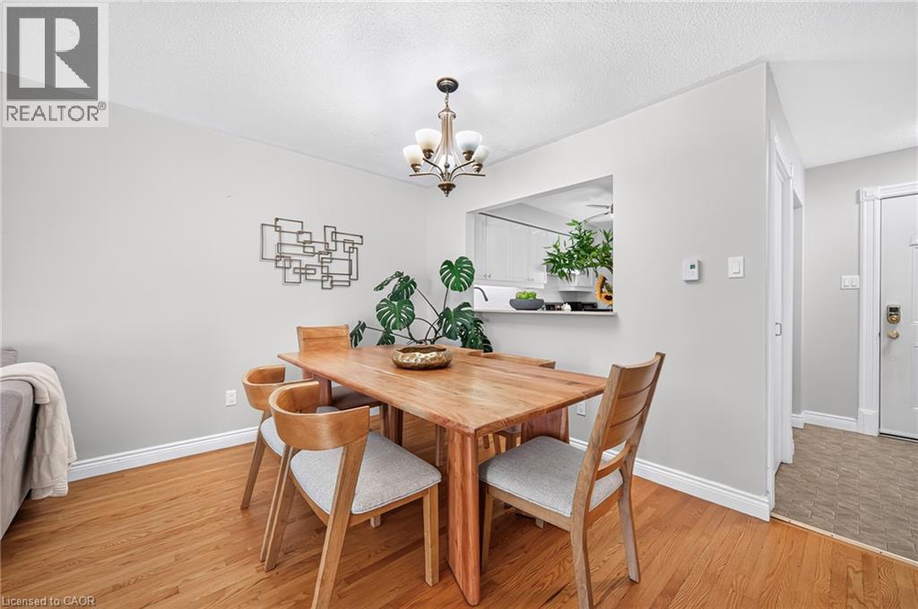 Hardwood flooring in a natural finish, a pass-through window, and a built-in ceiling light fixture - 1517 Elm Road Unit# 9, Oakville, ON