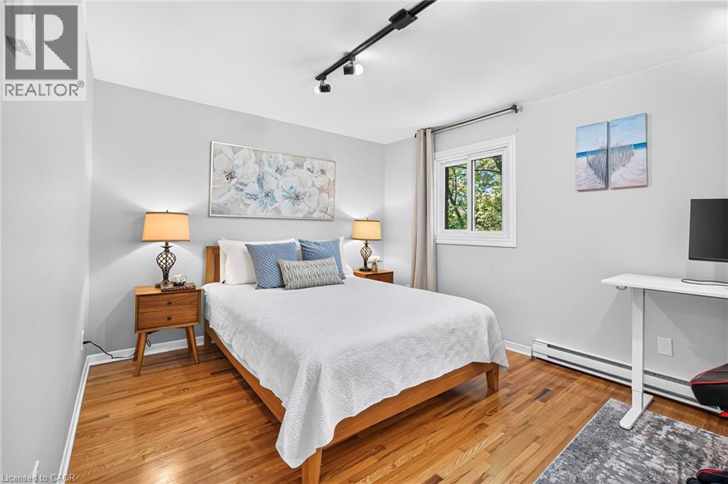 Hardwood-finish flooring, light grey wall paint, white window trim, and track lighting - 1517 Elm Road Unit# 9, Oakville, ON