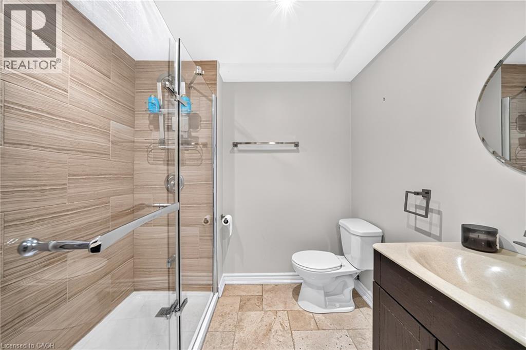 Glass-enclosed shower with horizontal tile surround and chrome fixtures - 1517 Elm Road Unit# 9, Oakville, ON