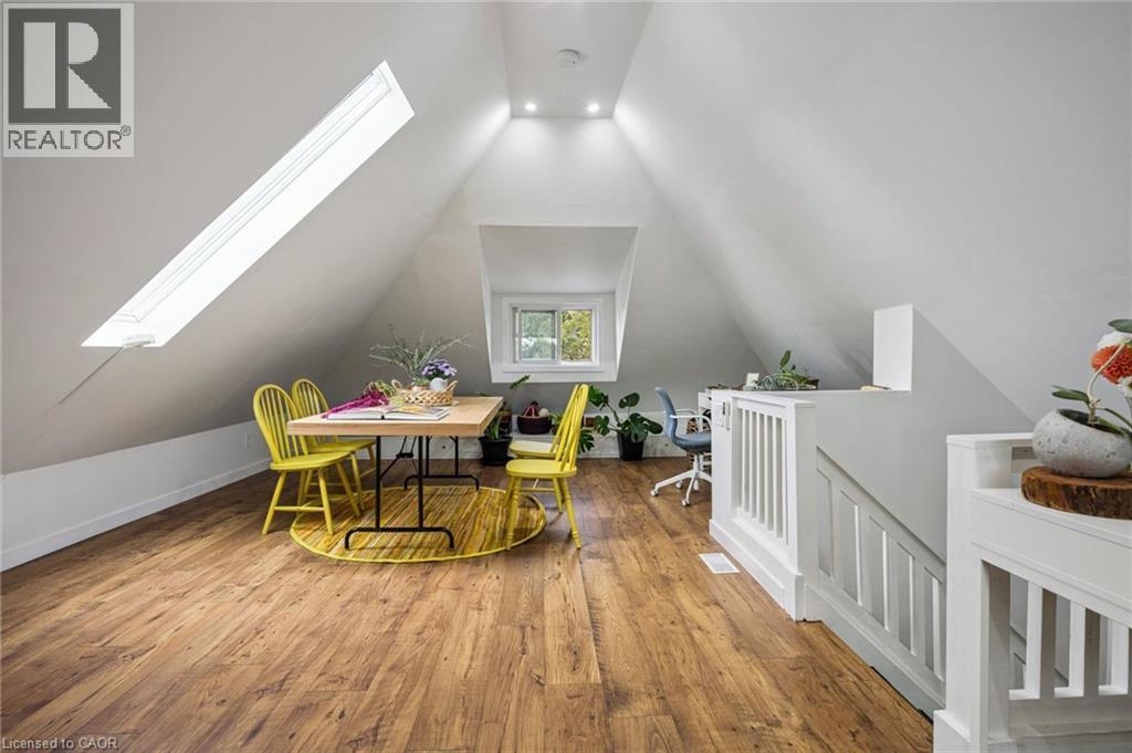 Recessed lighting, skylight, vinyl plack flooring, and white stair railings - 58 Balmoral Avenue N, Hamilton, ON