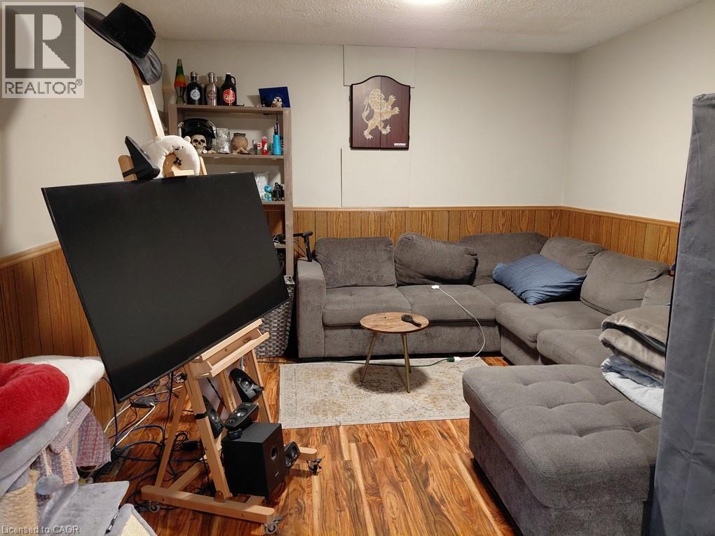 Wood-finish flooring with wood paneling accents - 244 Guildwood Drive, Hamilton, ON