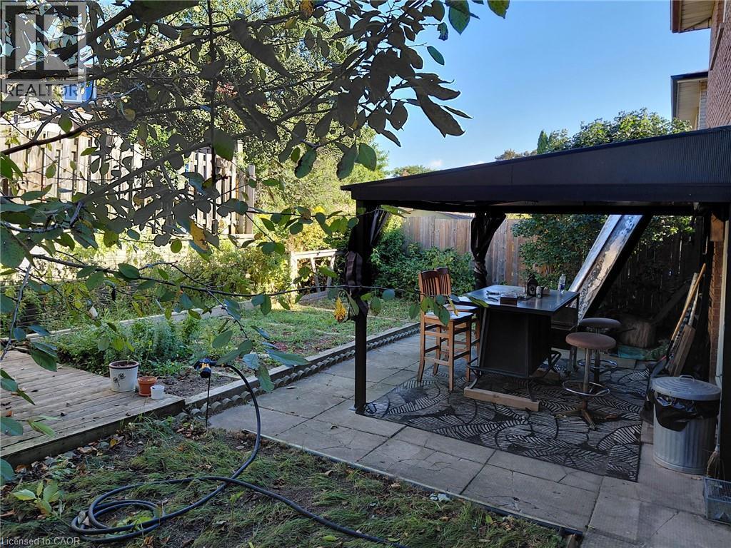 Patio area featuring paver stones, a black gazebo, and a raised garden bed - 244 Guildwood Drive, Hamilton, ON