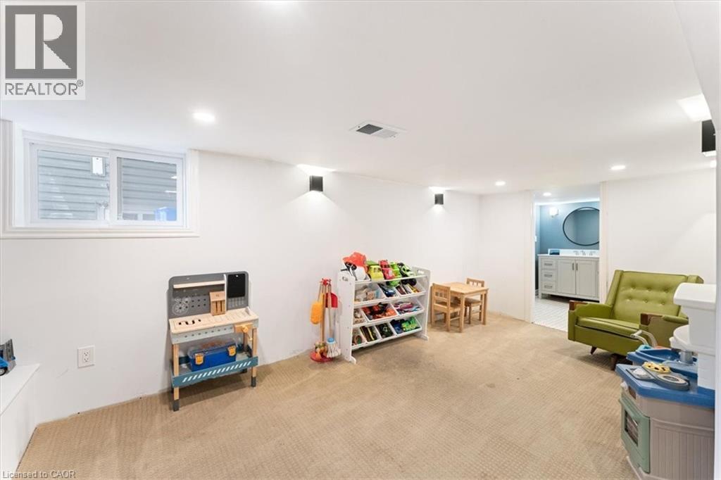 Spacious finished room with neutral carpeting, recessed lighting, and wall-mounted sconces - 17 Craigmiller Avenue, Hamilton, ON