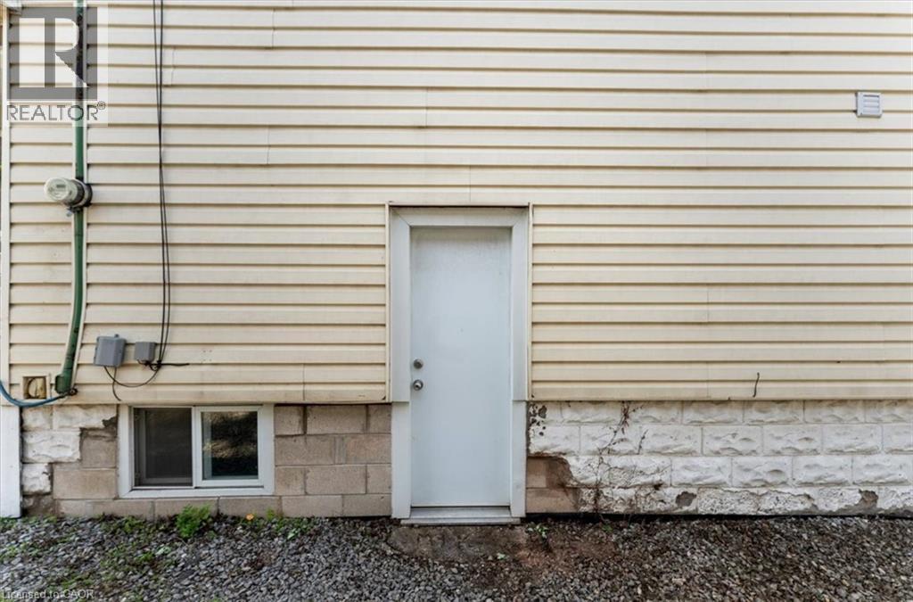 Cream-colored horizontal siding with a white exterior door - 17 Craigmiller Avenue, Hamilton, ON