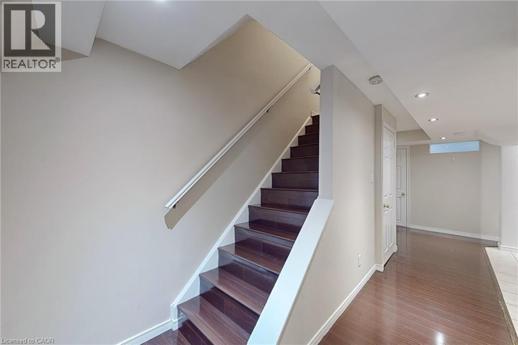 Staircase featuring wood-finish treads and risers, white handrail, recessed lighting, and wood-finish flooring - 21 Eastview Gate Unit# 36, Brampton, ON