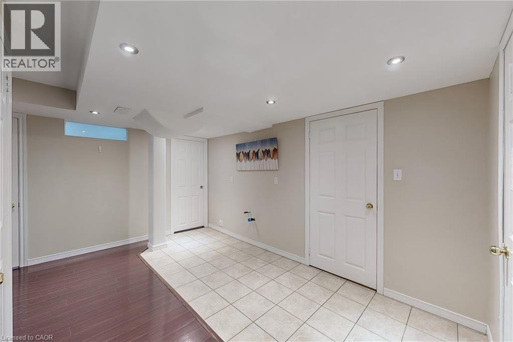 Recessed lighting illuminates neutral-toned walls and a combination of tile and wood-finish flooring - 21 Eastview Gate Unit# 36, Brampton, ON