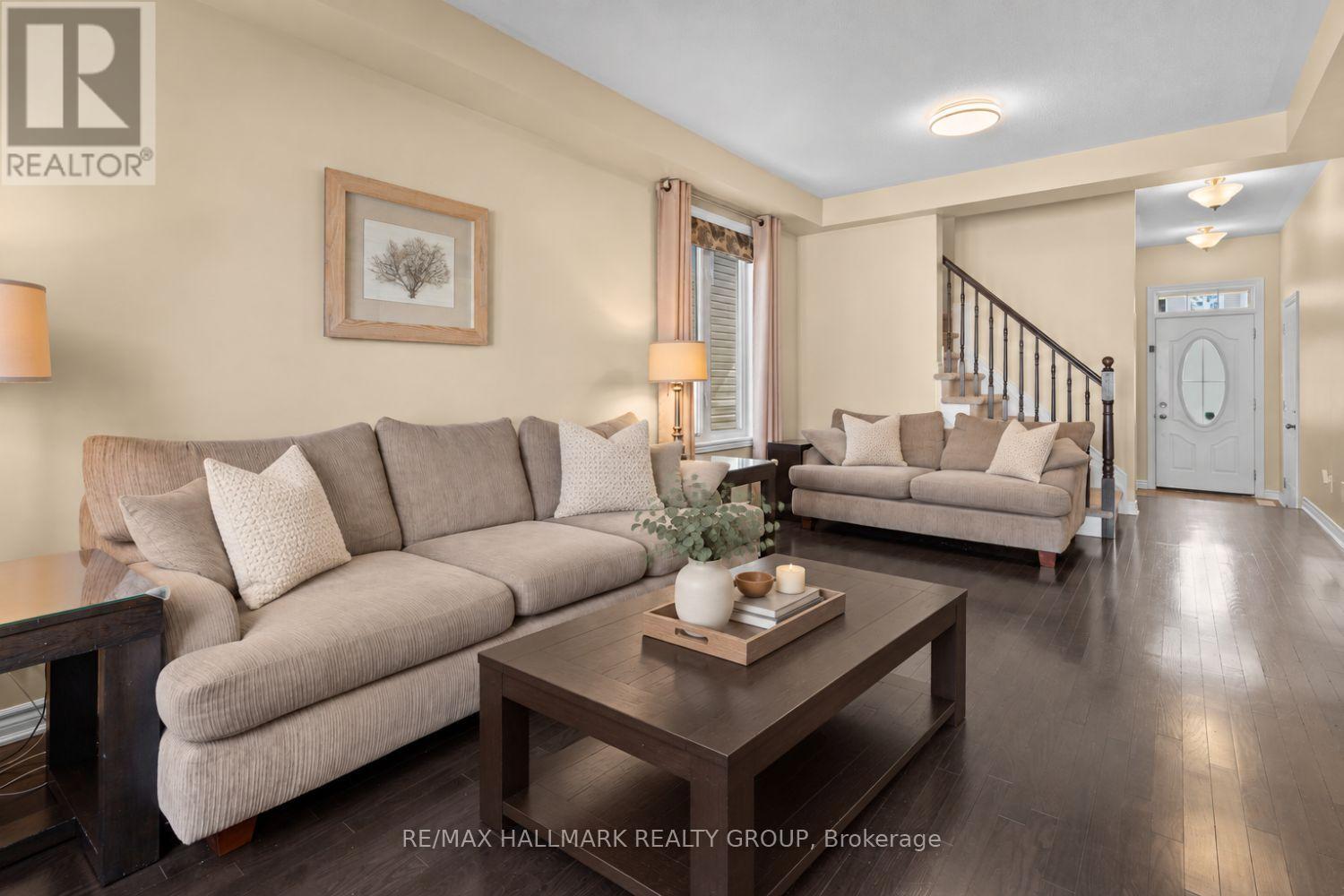 Living room with open staircase and hardwood - 223 Serra Ridge, Ottawa, ON