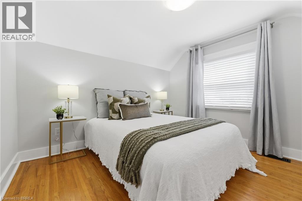 Hardwood flooring, sloped ceiling, window with blinds, ceiling-mounted light fixture, white wall finishes - 87 Strathcona Avenue, Brantford, ON