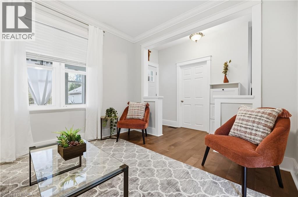 Wood-finish flooring, white trim, and crown molding accent the interior space - 87 Strathcona Avenue, Brantford, ON
