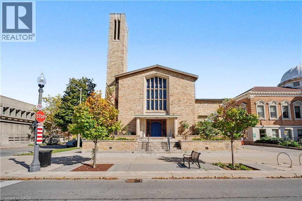 Stone facade with a tall bell tower and large arched windows - 97 Wellington Street, Brantford, ON