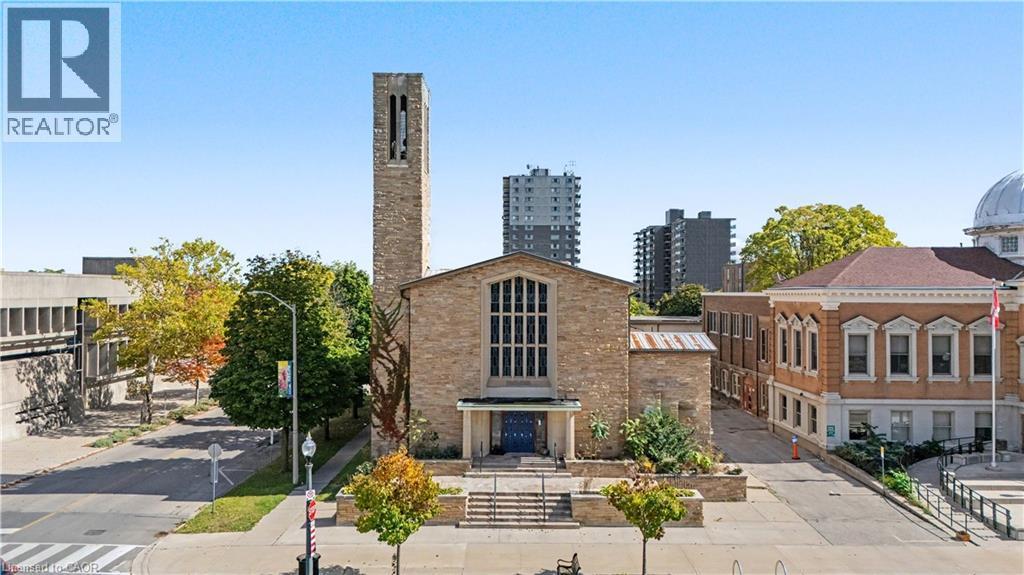 Stone masonry facade with prominent bell tower and large multi-pane windows - 97 Wellington Street, Brantford, ON