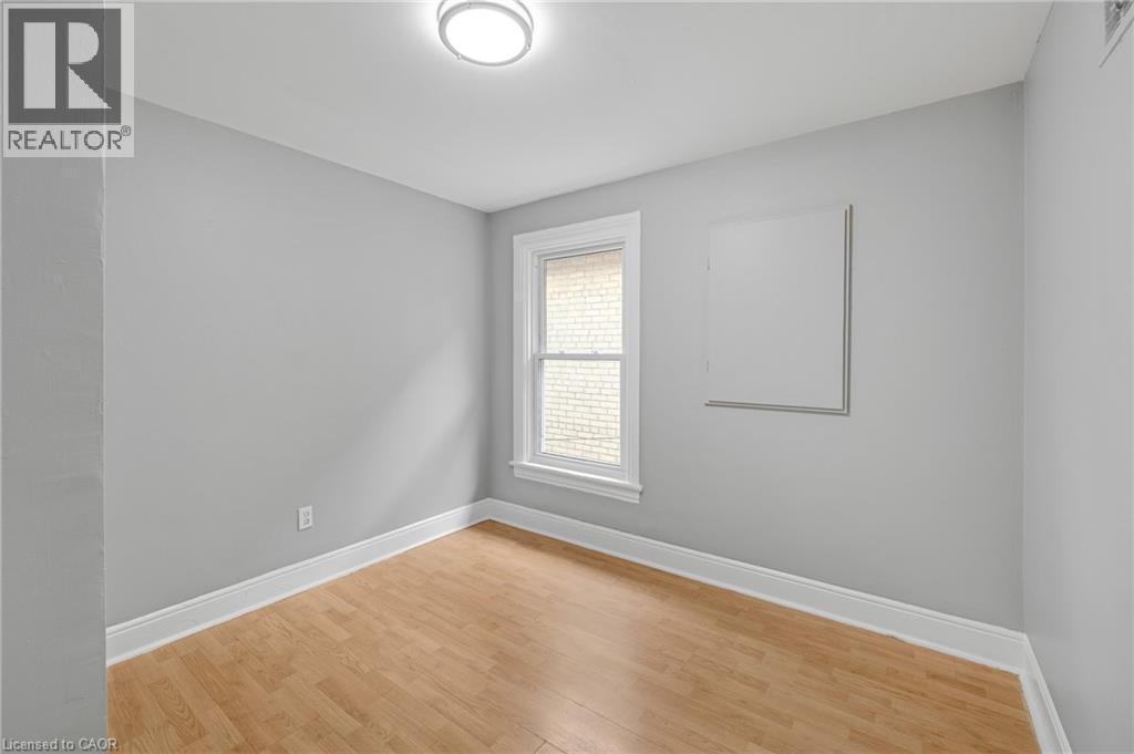 Wood-finish flooring, white trim, and a window with a white frame - 211 Wentworth Street N, Hamilton, ON