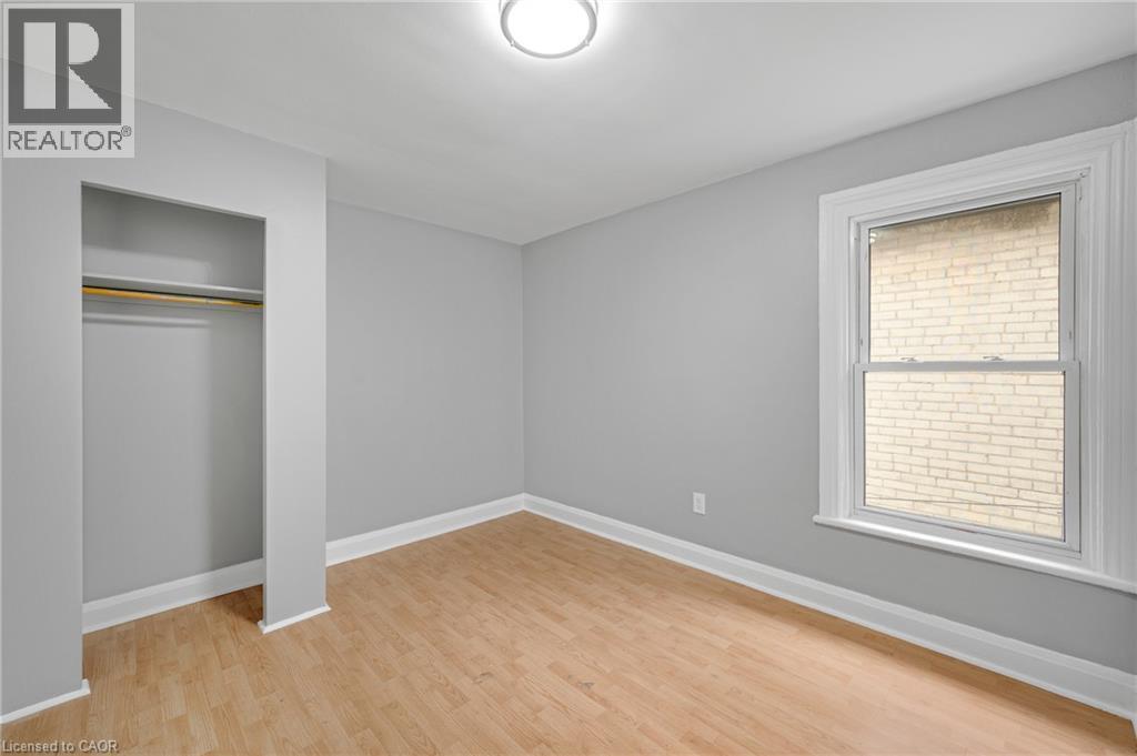 Recessed closet with a clothes rod, wood-finish flooring, single window, and a ceiling-mounted light fixture - 211 Wentworth Street N, Hamilton, ON