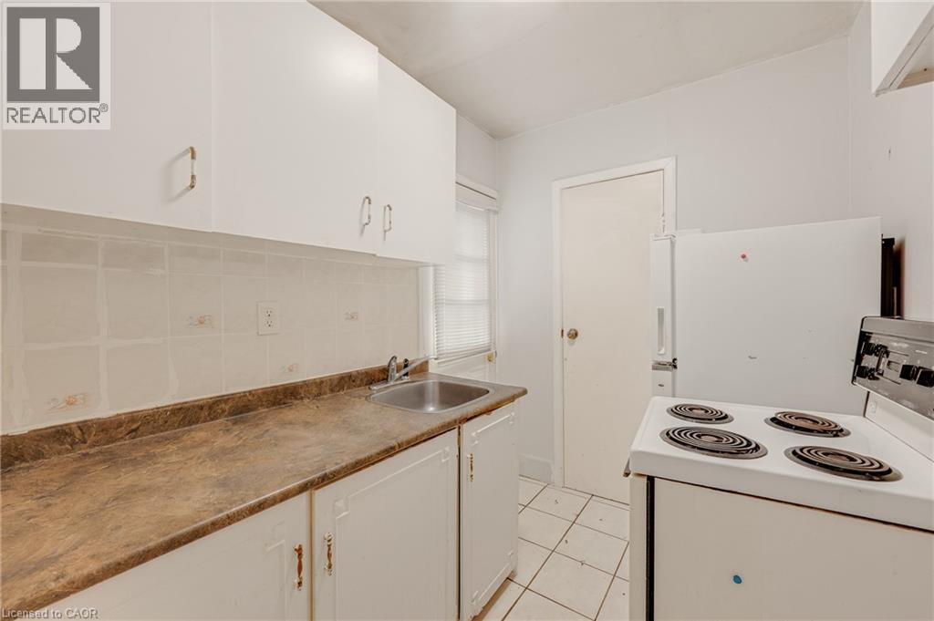 White cabinetry with bronze-finish hardware - 211 Wentworth Street N, Hamilton, ON