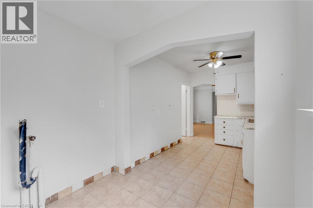 Tiled flooring extending into kitchen area, white walls, and an arched doorway - 211 Wentworth Street N, Hamilton, ON