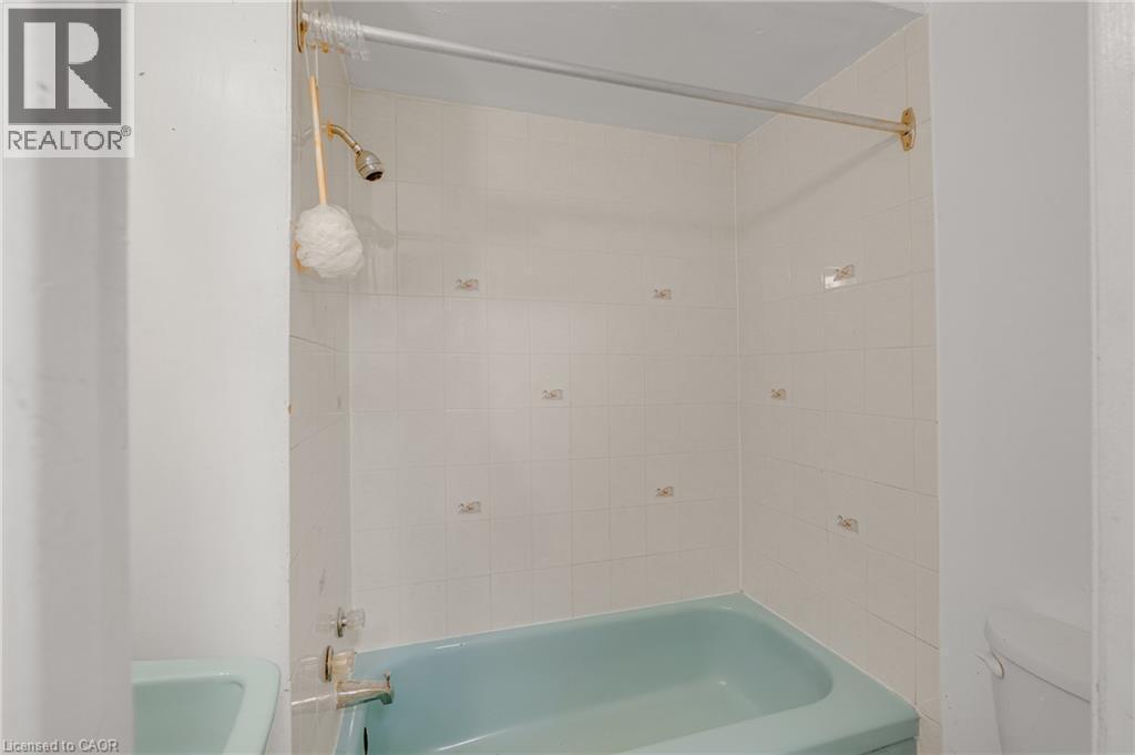 Bathroom featuring a bathtub with a shower and white tiled walls - 211 Wentworth Street N, Hamilton, ON