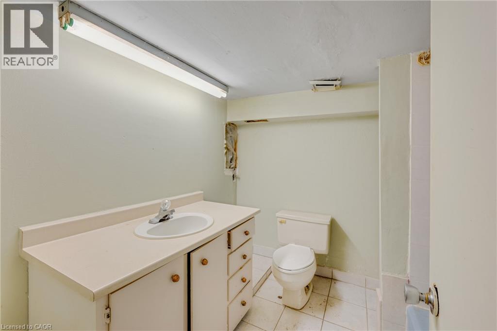White vanity with an integrated sink and chrome faucet - 211 Wentworth Street N, Hamilton, ON