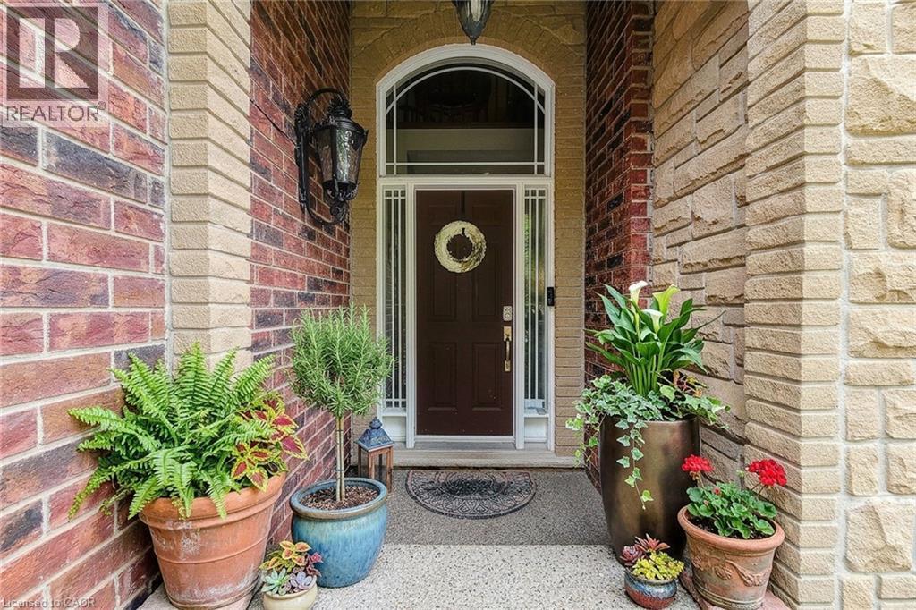 Brick and stone exterior with an arched entryway - 214 Cloverleaf Drive, Ancaster, ON
