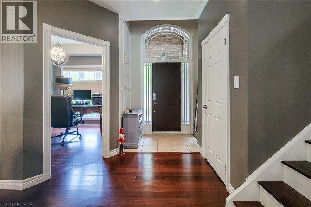 Arched transom window and sidelights frame the front door - 214 Cloverleaf Drive, Ancaster, ON