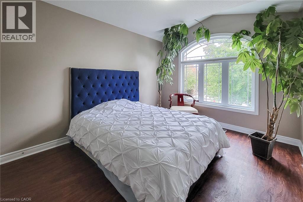 Arch-top window, wood-finish flooring, neutral wall color - 214 Cloverleaf Drive, Ancaster, ON