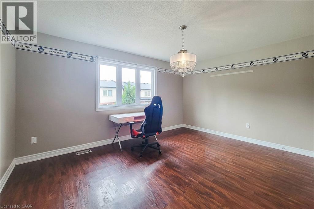 Wood-finish flooring, neutral wall paint, and a multi-pane window - 214 Cloverleaf Drive, Ancaster, ON