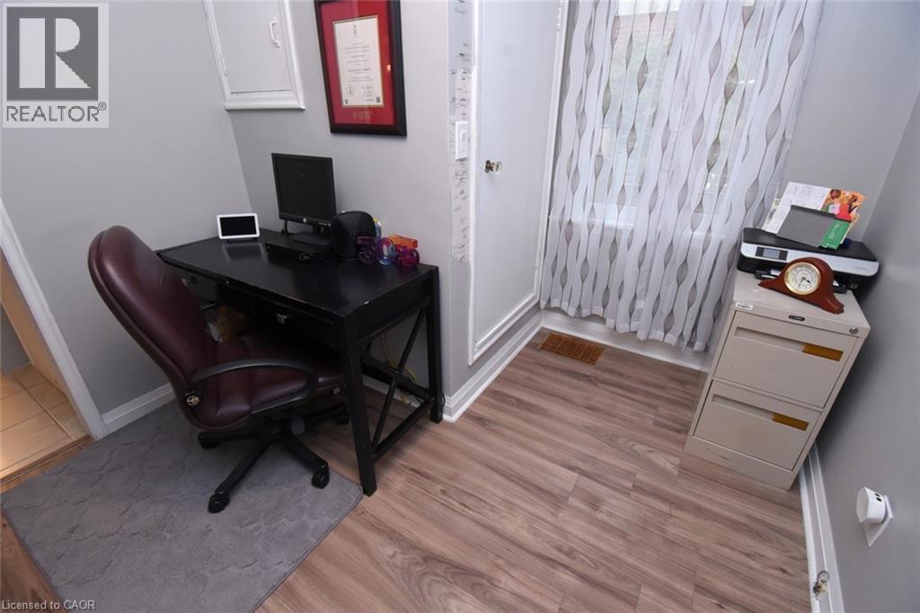 Wood-finish flooring with white trim, light gray painted walls, and a window with sheer curtains - 154 Ewen Road, Hamilton, ON