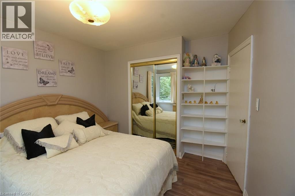 Recessed lighting, wood-finish flooring, mirrored closet doors, built-in shelving, and light-colored walls - 154 Ewen Road, Hamilton, ON