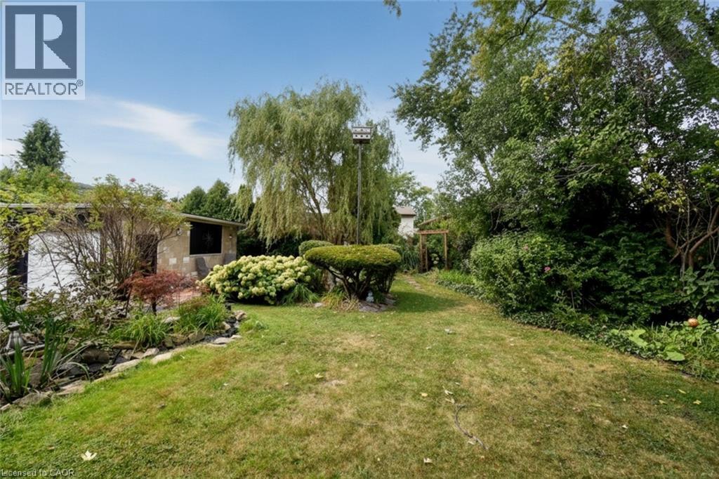 Expansive backyard featuring a manicured lawn, established landscaping, and mature trees - 154 Ewen Road, Hamilton, ON