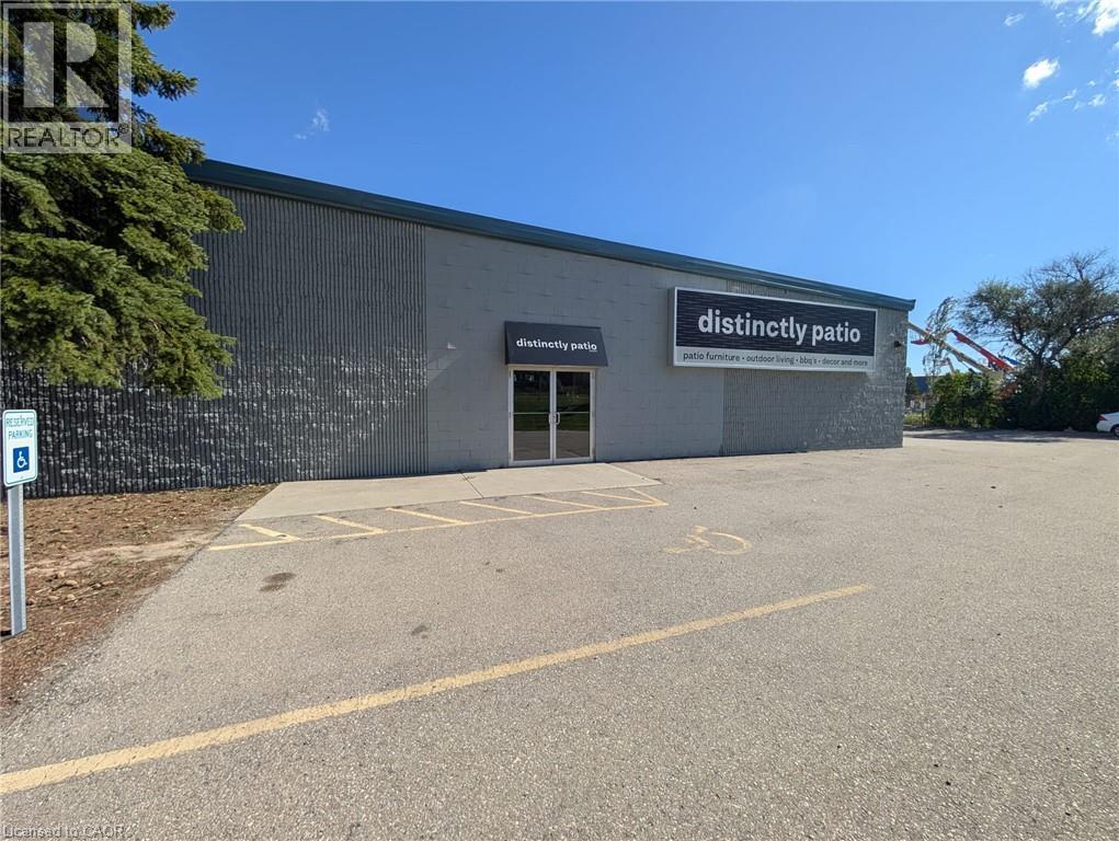 Commercial building featuring a textured facade, dual glass entry doors, and a prominent exterior sign - 97 Ardelt Avenue, Kitchener, ON