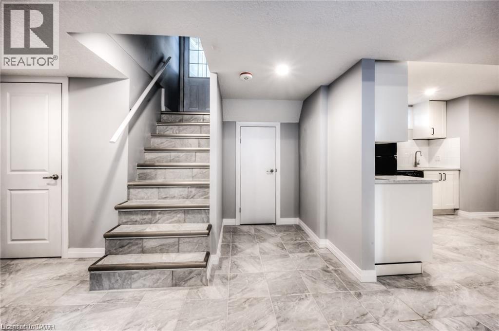 Tile flooring throughout, recessed lighting, and a built-in kitchen area with white cabinetry - 33 Ruskview Road Unit# Lower, Kitchener, ON