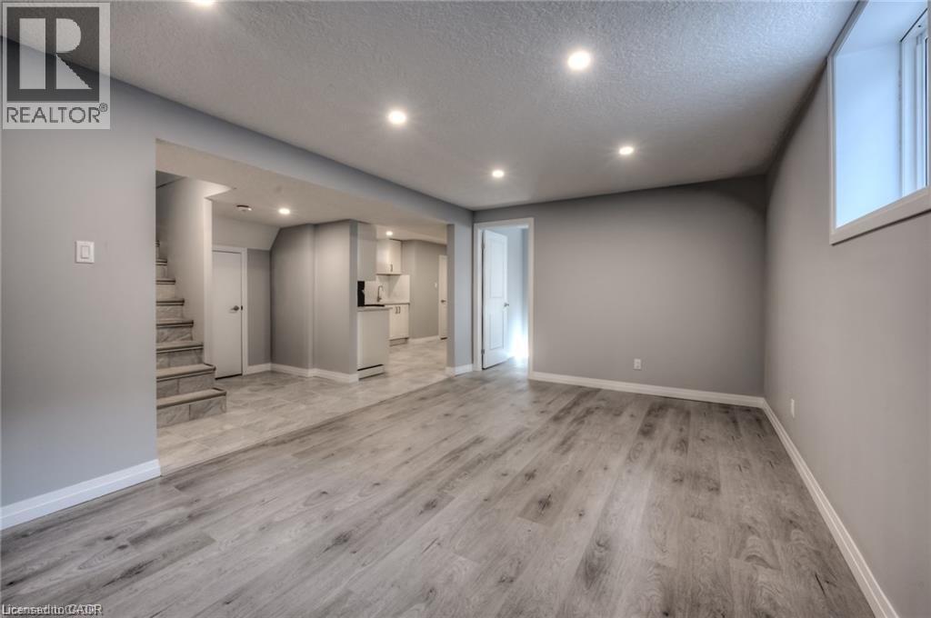 Recessed lighting, light wood-finish flooring, light gray wall tones, a white trim window, and a white interior door - 33 Ruskview Road Unit# Lower, Kitchener, ON