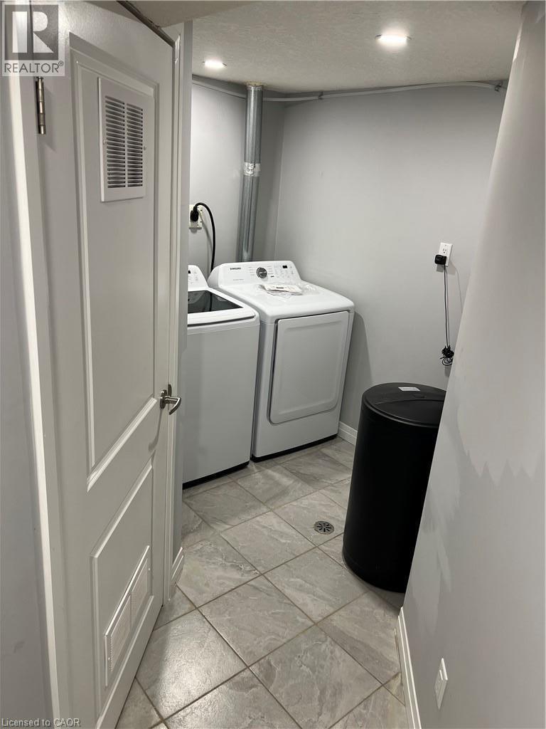 Laundry area featuring ceramic tile flooring, recessed lighting, and a paneled door - 33 Ruskview Road Unit# Lower, Kitchener, ON