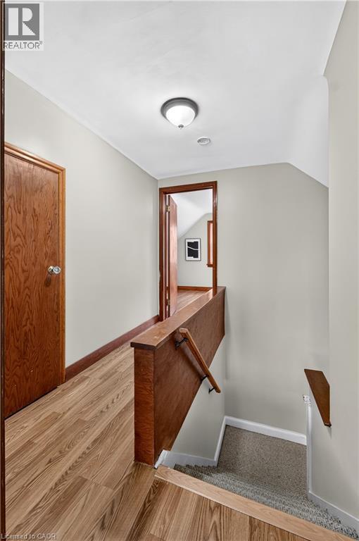 Wood-finish flooring with a wood railing and wall-mounted handrail - 176 Avalon Place, Kitchener, ON