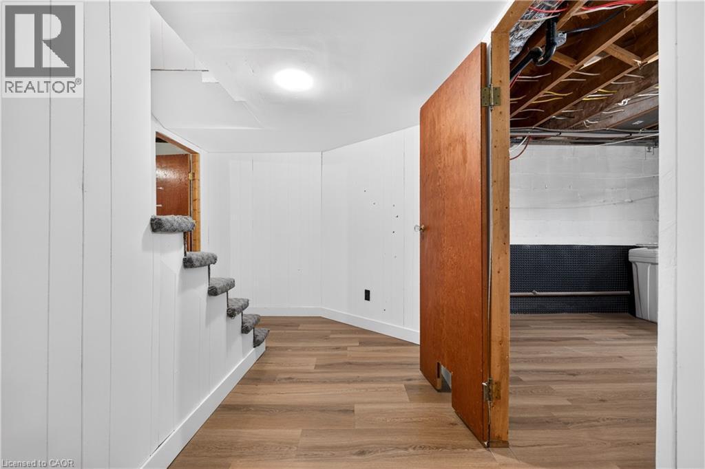 Wood-finish flooring, white paneled walls, and recessed lighting - 176 Avalon Place, Kitchener, ON
