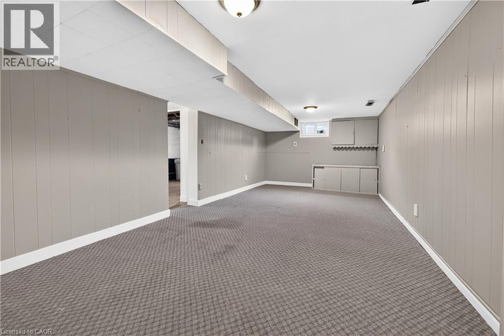 Finished lower level featuring neutral wall paneling, recessed lighting, built-in cabinetry, and patterned carpeting - 176 Avalon Place, Kitchener, ON