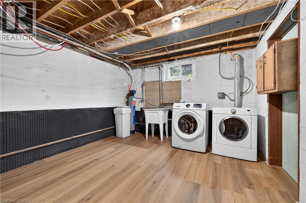 Wood-finish flooring with white block walls and a utility sink - 176 Avalon Place, Kitchener, ON