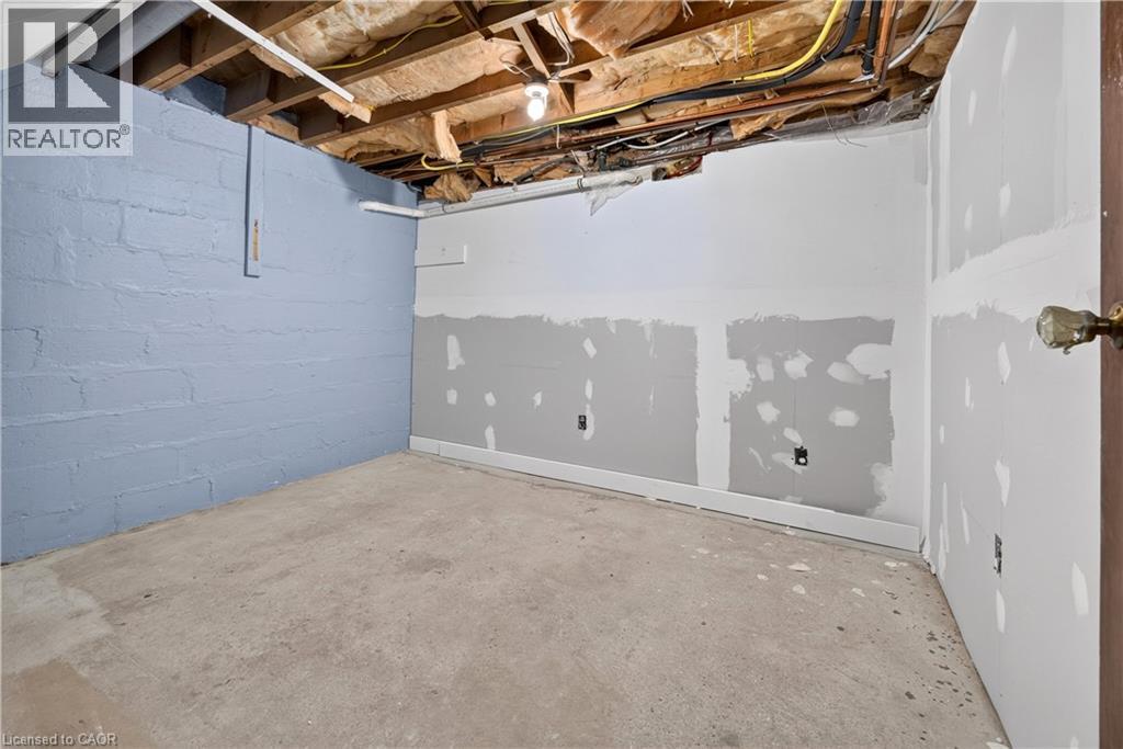 Unfinished space featuring exposed ceiling joists, concrete flooring, and partial drywall installation - 176 Avalon Place, Kitchener, ON